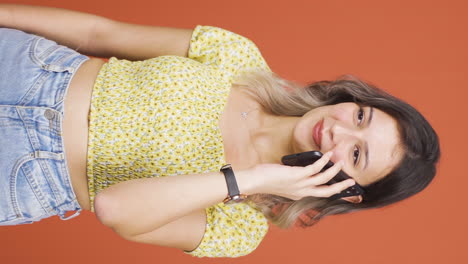 Vertical-video-of-Happy-talking-young-woman-on-the-phone.